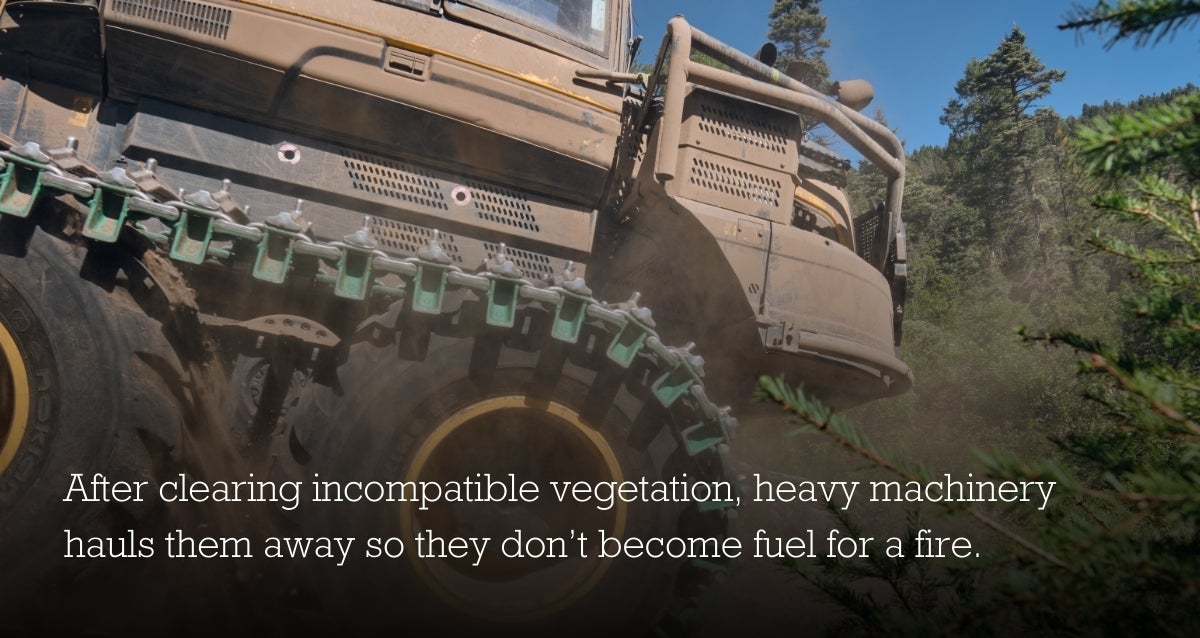Background image of tractor with words over: After clearing incompatible vegetation, heavy machinery hauls them away so they don't become fuel for a fire.